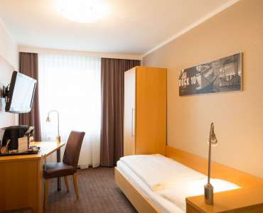 Bett und Schreibtisch im Einzelzimmer Standard im Heikotel City Nord Bett und Schreibtisch im Einzelzimmer Standard im Heikotel City Nord