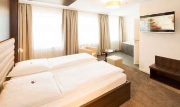 Großes Doppelbett in der Whirlpoolsuite im Hotel Windsor.