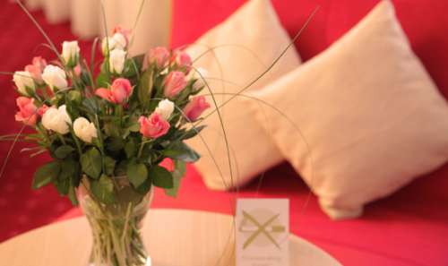 Blumenstrauß vor einer roten Couch im Hotel Windsor